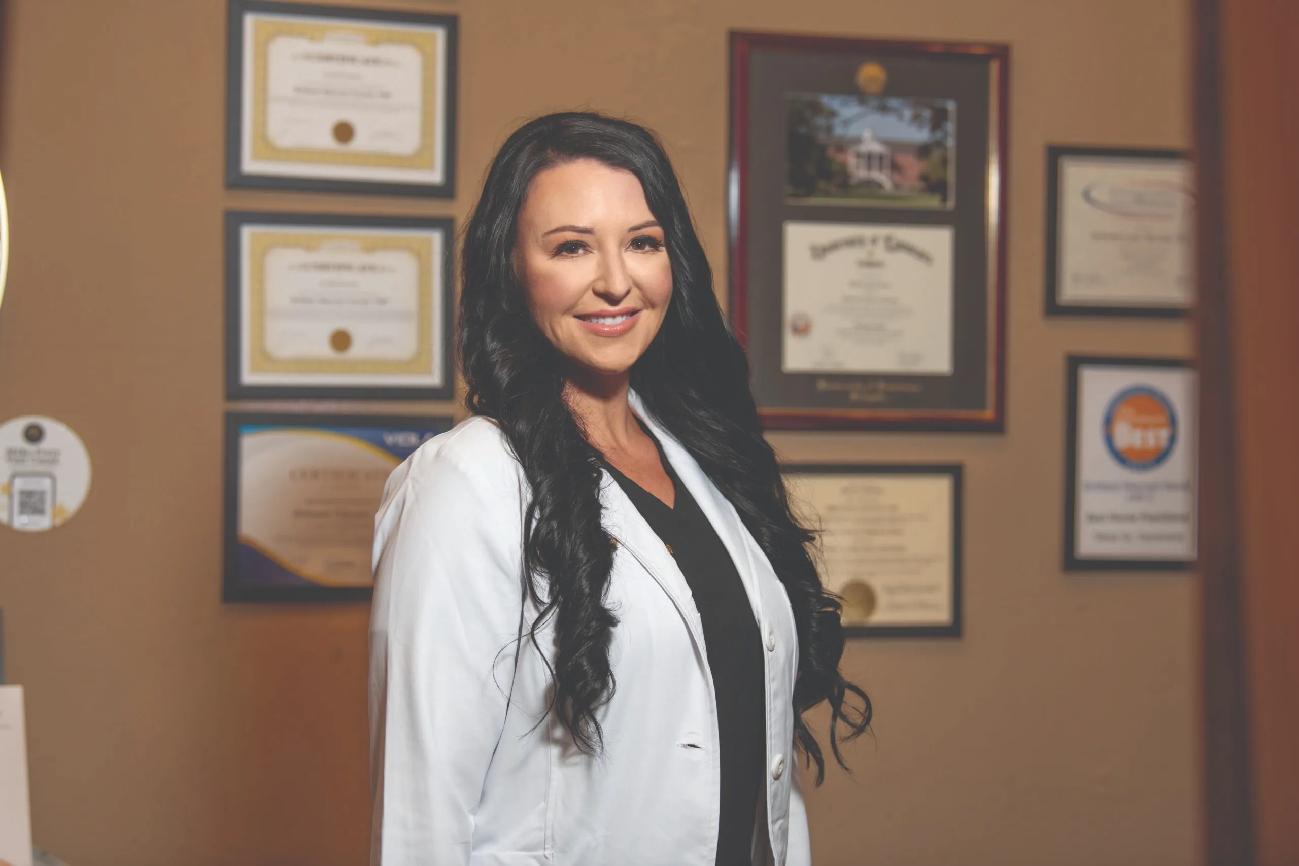 Brittani, NP-C standing in front of her clinical credentials